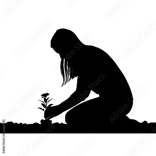 Silhouette of a person planting a small flower in fertile soil at sunrise