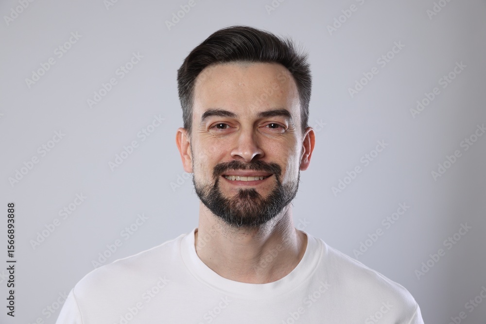Obraz premium Portrait of smiling man on grey background, closeup