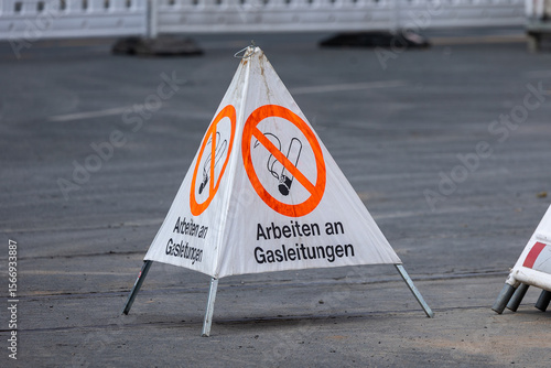 Schilderij op canvas Ein dreiseitiges Warnschild auf einer Baustelle am Rathenauplatz in Nürnberg weist mit dem Hinweis „Arbeiten an Gasleitungen“ und durchgestrichenem Raucher-Symbol auf laufende Gasarbeiten hin