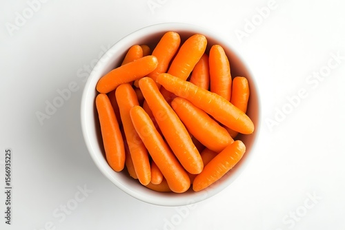 Overhead shot of a bowl full of fresh baby carrots on white