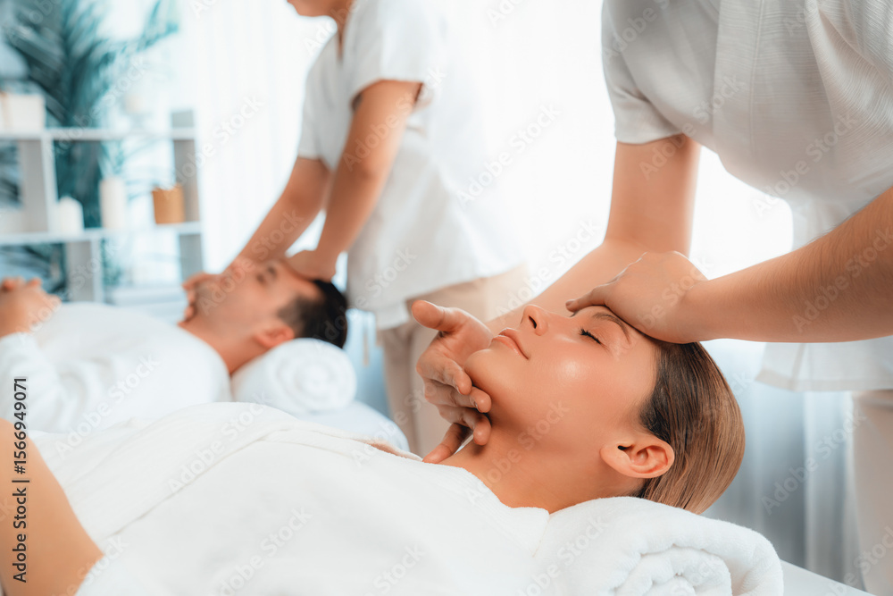 Obraz premium Caucasian couple enjoying relaxing anti-stress head massage and pampering facial beauty skin recreation leisure in dayspa modern light ambient at luxury resort or hotel spa salon. Quiescent