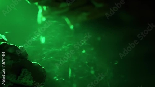 Abstract green light with dust particles floating through a dark space