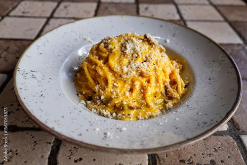 Photography Authentic Roman carbonara pasta with guanciale and pecorino on rustic ceramic pl