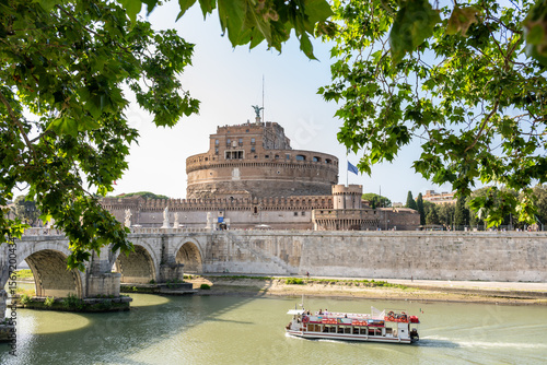 Photography Castle Sant Angelo and a cruise boat on the river Tiber in Rome, Italy