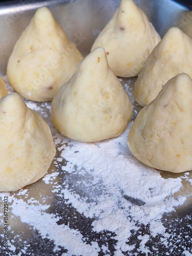 Brazilian Coxinha Dough Shapes on Floured Tray. Traditional Homemade Snack Preparation