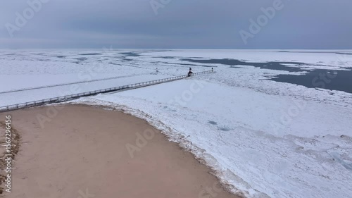 Lighthouse frozen Lake Michigan drone view