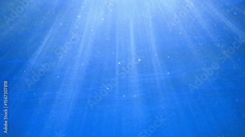 Ocean blue underwater with sunrays, Underwater Sea Deep Water Abstract Sunshine, sea wave , clean waters in summer time, Natural underwater seascape, sand on ocean floor and water surface with sunligh