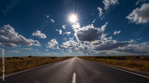 Road disappearing into horizon under July sun