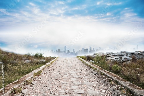 Foto Stony path leading to misty cityscape