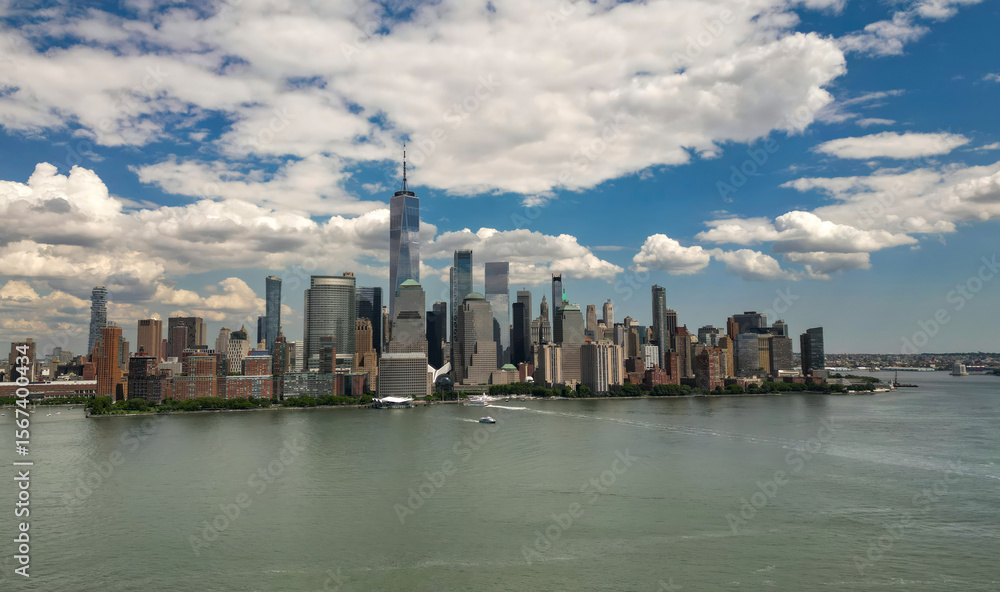 Fototapeta premium Manhattan aerial skyline, New York. Panorama view of New York city skyscrapers on blue sky. USA NYC. Lower NYC skyline on sunny day. New York cityscape. New York City with clouds from drone.