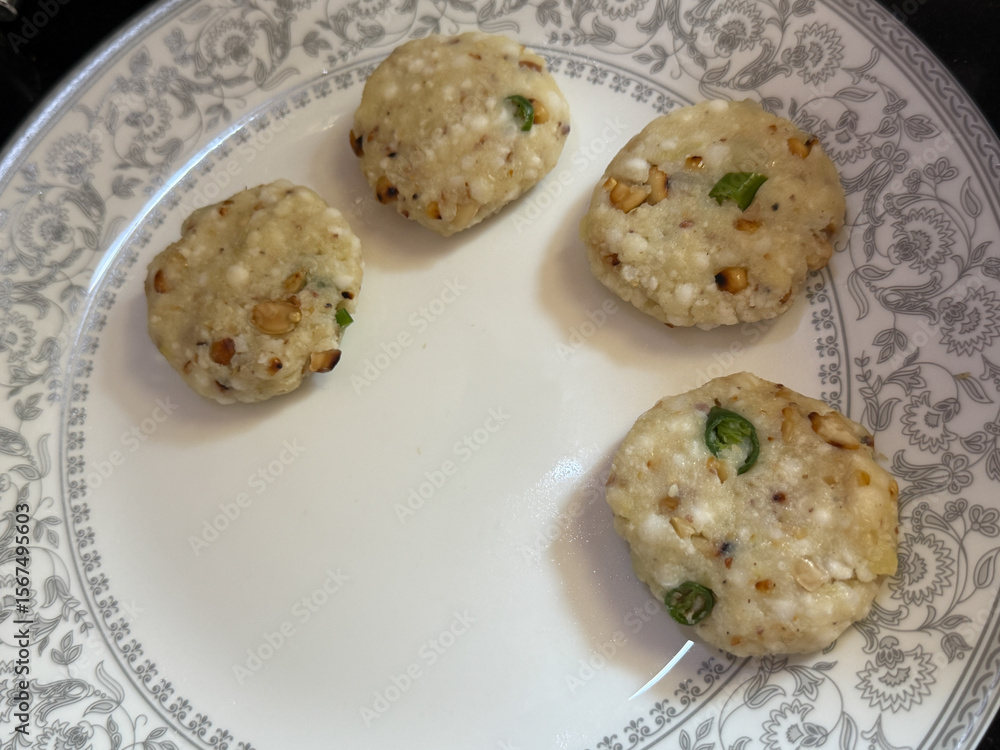 Fototapeta premium A plate of four small, round, white pastries with green peppers on top