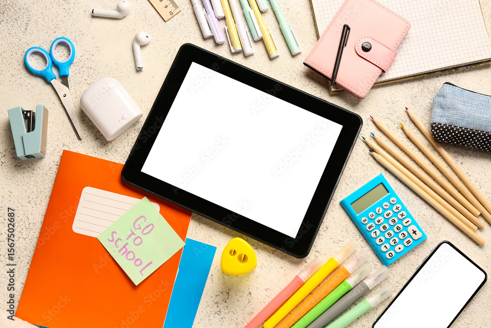 Sticky note with text GO TO SCHOOL, gadgets and different stationery on grunge white background Sticky note with text GO TO SCHOOL, gadgets and different stationery on grunge white background