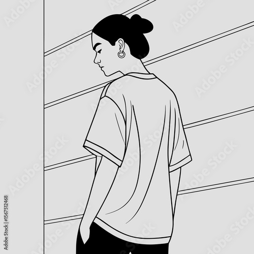 Stylish young woman with hair in a bun wearing a t shirt and pants with large hoop earrings looking down