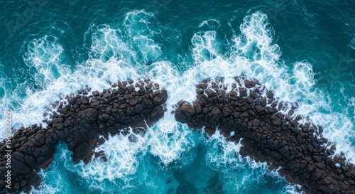 Ocean waves crashing over rocks, aerial view