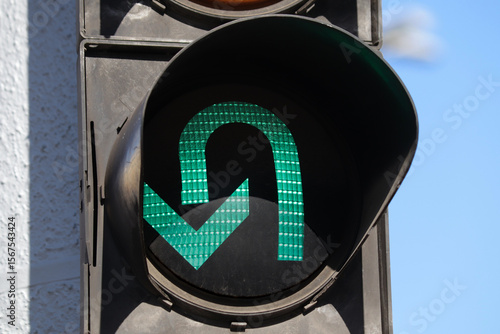 Close-up of a traffic light green arrow allowing U-turn.
