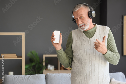 Mature man in headphones wi...