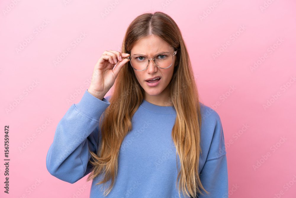 Young blonde woman isolated on pink background With glasses and frustrated expression Young blonde woman isolated on pink background With glasses and frustrated expression