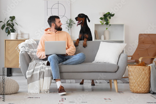 Young man with Dobermann do...
