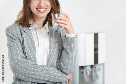 Smiling young woman drinkin...