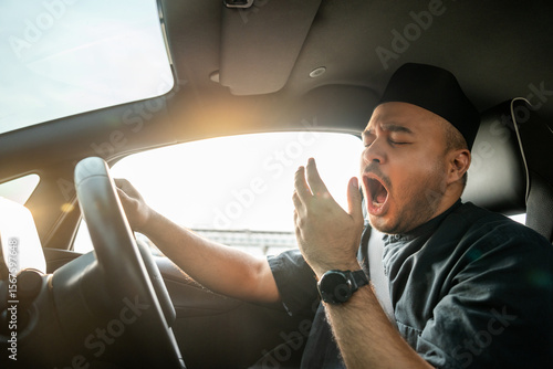 Foto Young asian muslim islamic driver was drowsy