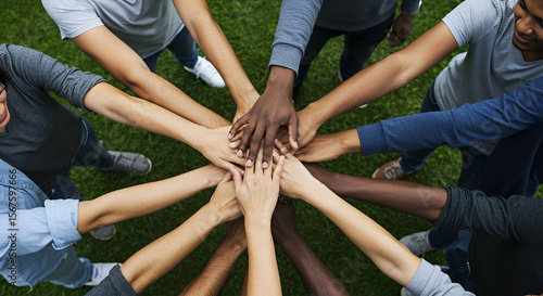 Diverse group of people joining hands in a circle outdoors, symbolizing unity and togetherness.