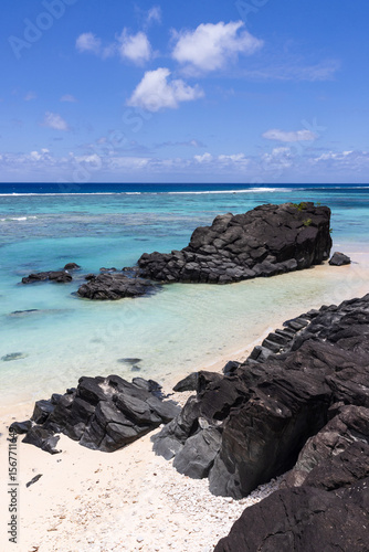 Фотография The striking basalt outcrop known as Black Rock, located on the northwest coast of Rarotonga in the Cook Islands, surrounded by clear turquoise tropical ocean and reef