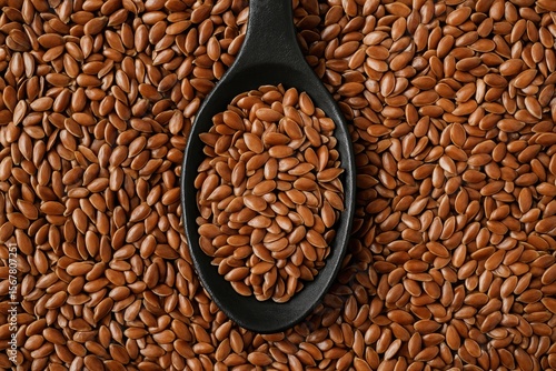 Dark-colored spoon featuring flaxseed atop it