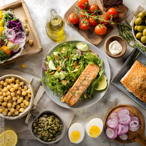 Grilled salmon salad with arugula, cucumber, nuts, and healthy side dishes displaying a balanced diet
