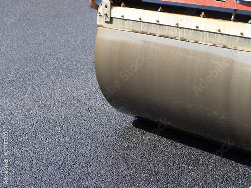 Road roller lays new asphal...