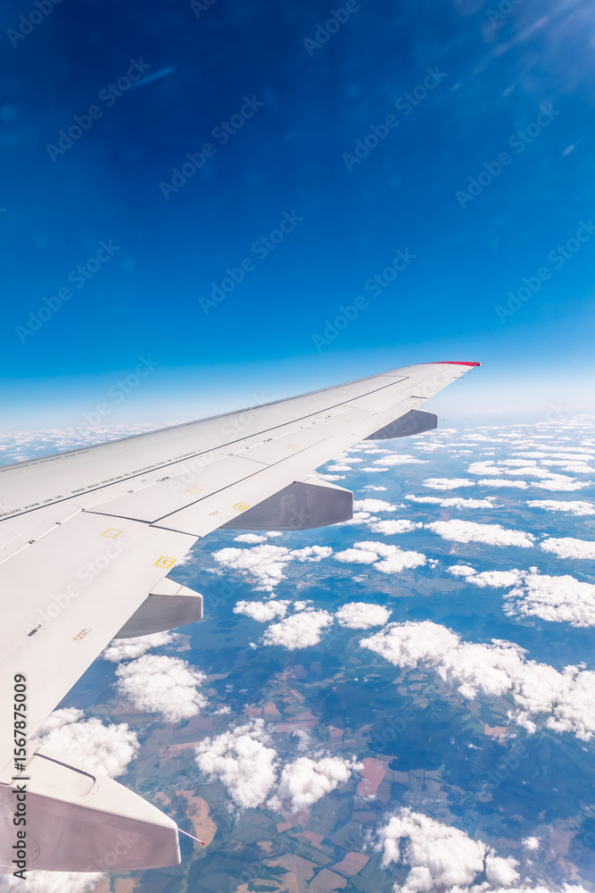 View from the airplane window at a beautiful cloudy sky and the airplane wing View from the airplane window at a beautiful cloudy sky and the airplane wing