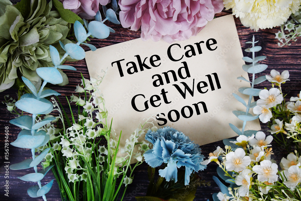 Fototapeta premium Take care and get well soon text with flowers bouquet decoration on wooden background