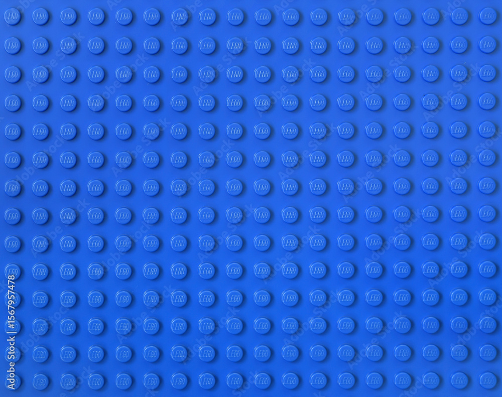 Naklejka premium Lego blue new baseplate with rows of round knots to assembly plastic bricks from popular toy brand. Editorial illustrative image of popular children plastic toy.
