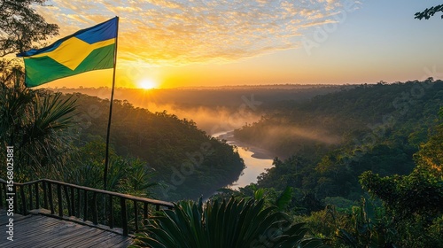 Flag gabon flying majestically above tropical forest canopy overlook with dramatic sunset lighting illuminating vast wilderness landscape