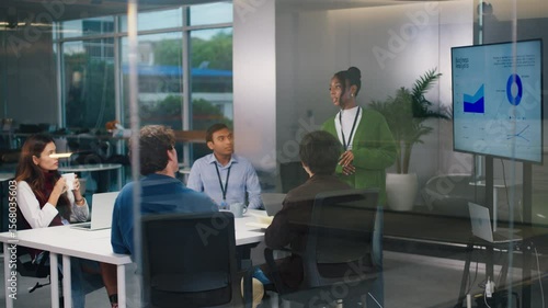 Confident CEO leads diverse startup tech team in night office meeting, brainstorming strategy, coding ideas, business growth, and software development with programmers and professionals collaborating