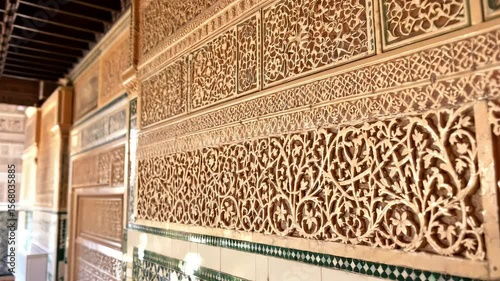 A close-up of the ornate tile work and carvings in the Alhambra, showcasing the delicate and detailed Islamic art on the walls