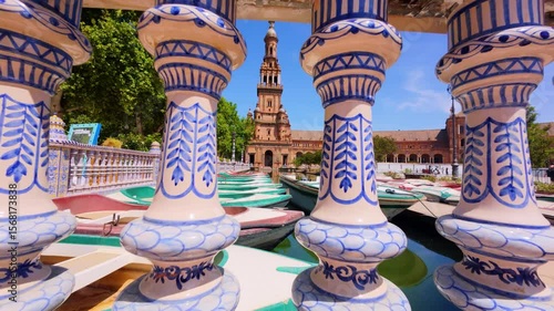 Painted ceramic columns in the Plaza de España in Seville with tower in the background, contrast of colors and shapes that define the Andalusian regionalist architectural style.
