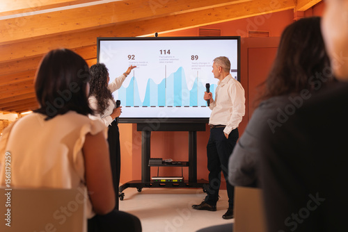 Obraz na plátně A woman with Latin features, explains to her teammates a report with data and a