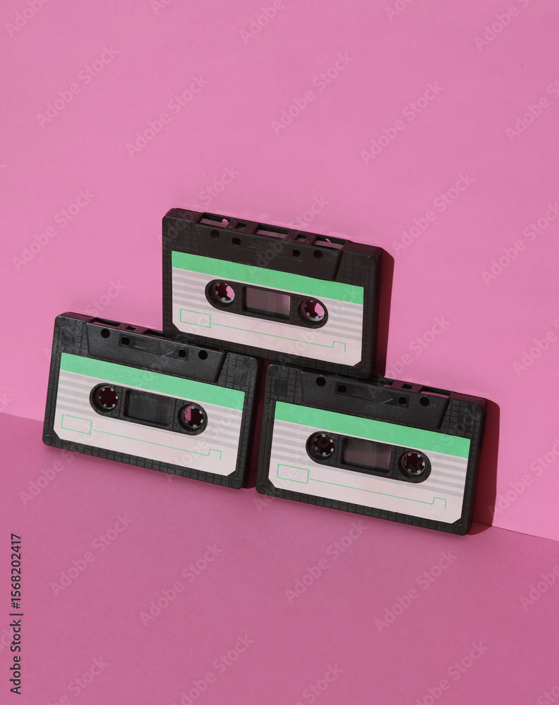 Fototapeta premium Retro 80s audio cassettes on pink background with shadow. Creative layout, minimalism, music lover