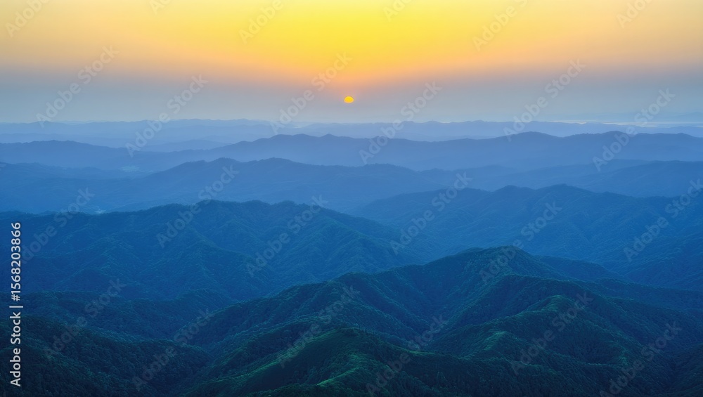 Obraz premium Golden sunrise over blue mountain layers mountains