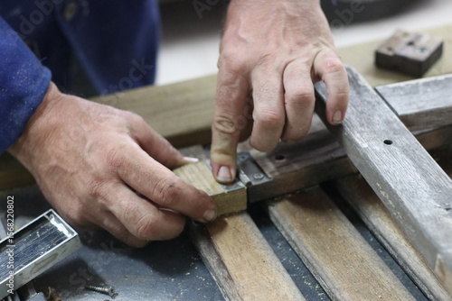 Carpenter making a table from recycled wood with a hinge