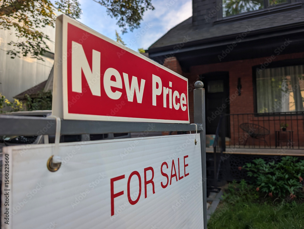 Sign for sale new price by detached house in residential area. Real estate market volatility, bubble, crash, hot and cooling housing market, overpriced property, buyer activity concept. Sign for sale new price by detached house in residential area. Real estate market volatility, bubble, crash, hot and cooling housing market, overpriced property, buyer activity concept.