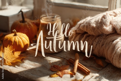 autumn banner with text hello autumn, cup of hot drink on wooden window sill, pimpkins and fallen leaves