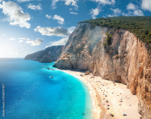 Fototapeta Naklejka Na Ścianę i Meble -  Aerial view of blue sea, rock, sandy beach at sunset in summer. Porto Katsiki, Lefkada island, Greece. Beautiful landscape with sea coast, azure water, sky, clouds. Top view of shore. Travel