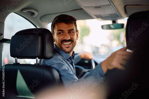Happy businessman parking car in reverse.