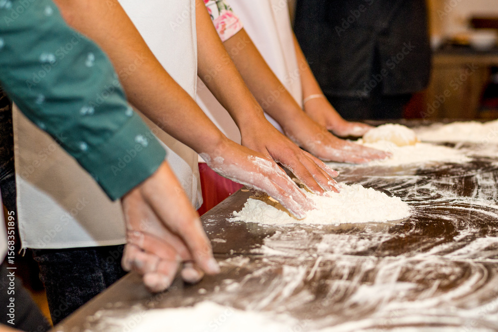Fototapeta premium Women's hands smeared in flour and flour on the table