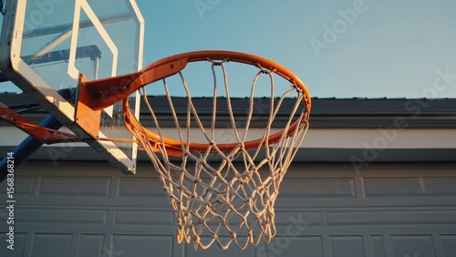 Basketball hoop against blue sky at suburban home
