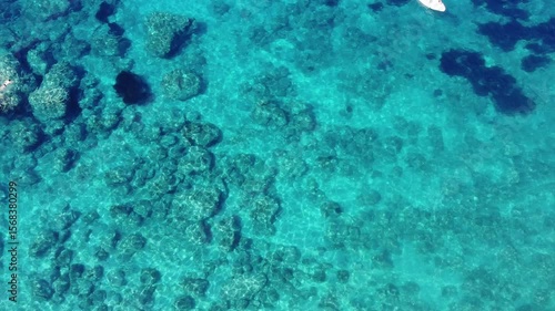 4K aerial top-down view of turquoise water in Corfu, Greece on a sunny day