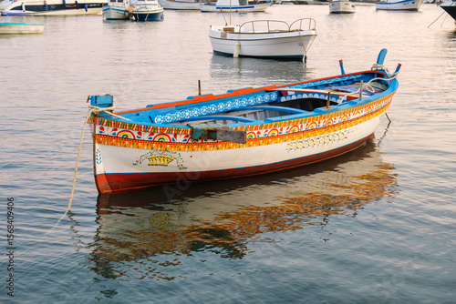 Traditional Sicilian fishing boat in Marzamemi harbor at sunset
