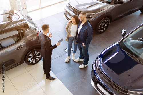 Valokuva Top view of smiling couple talking to car salesman in a dealership