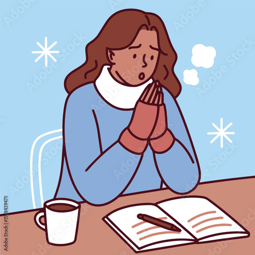 Dark-skinned woman tries to study or work in cold room wearing sweater and holding warm mug near book while snow falls outside